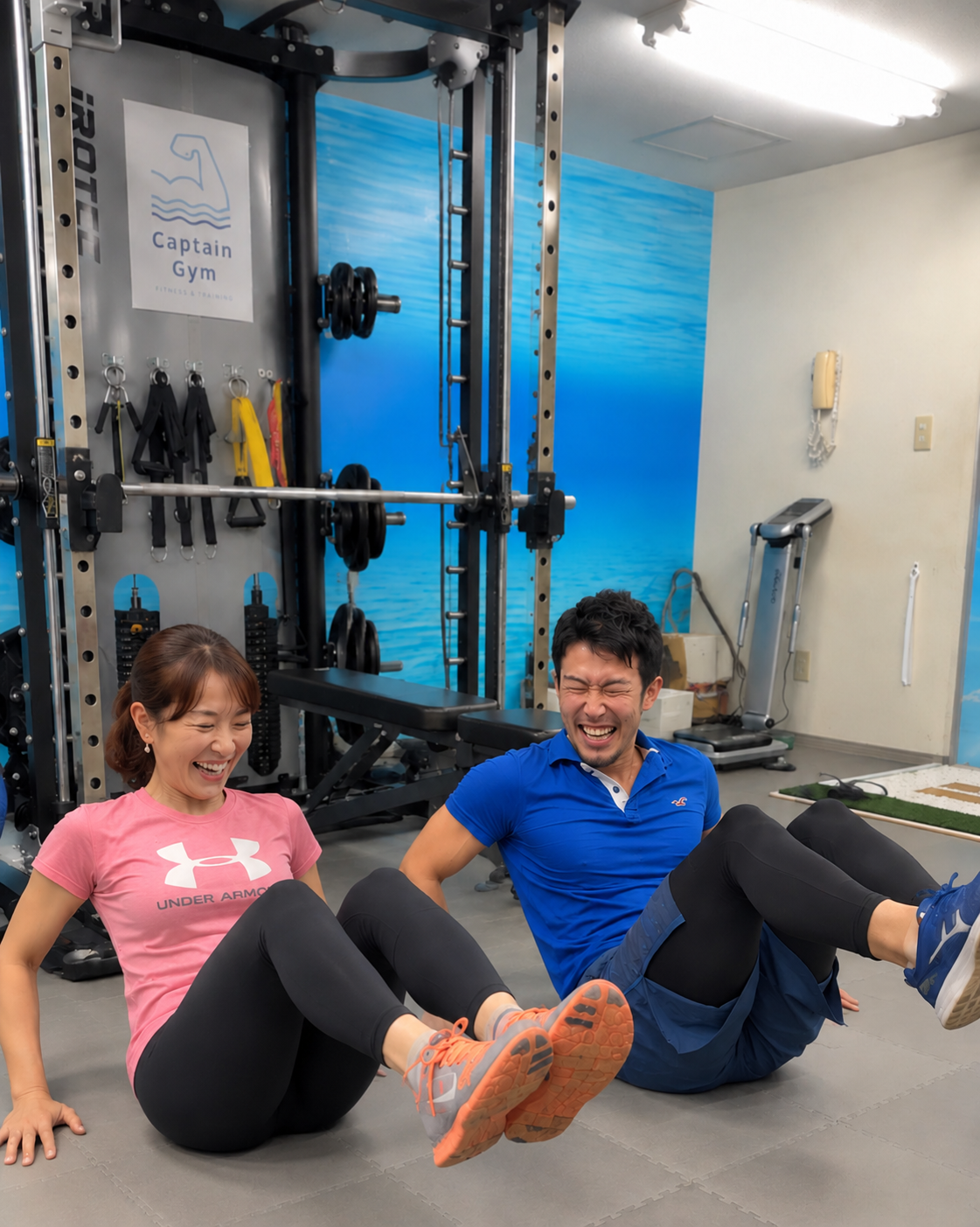女性とトレーナーが笑顔で腹筋トレーニングをする様子